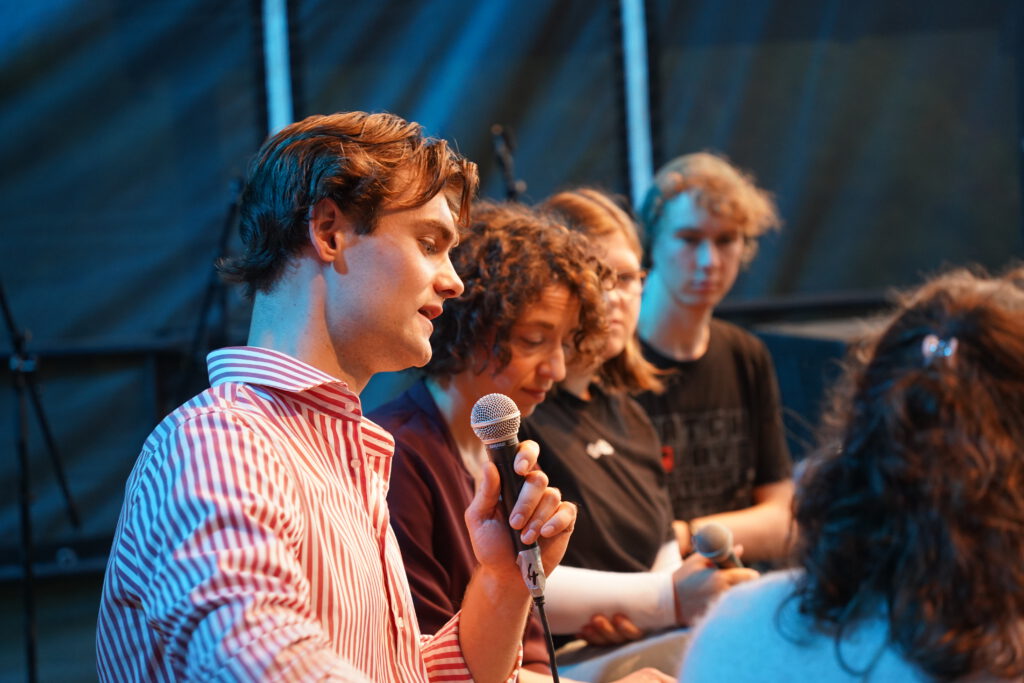 Mehrere Personen diskutieren auf einer Bühne.