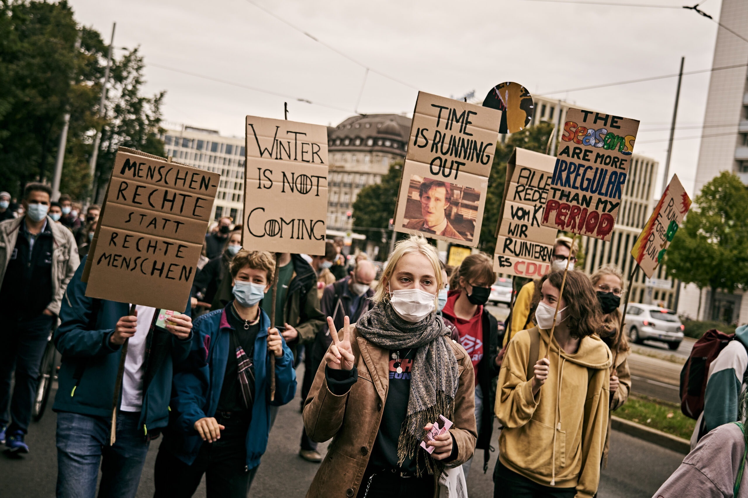 Mehrere Menschen halten Schilder auf dem Klimastreik von Fridays for Future Leipzig hoch.