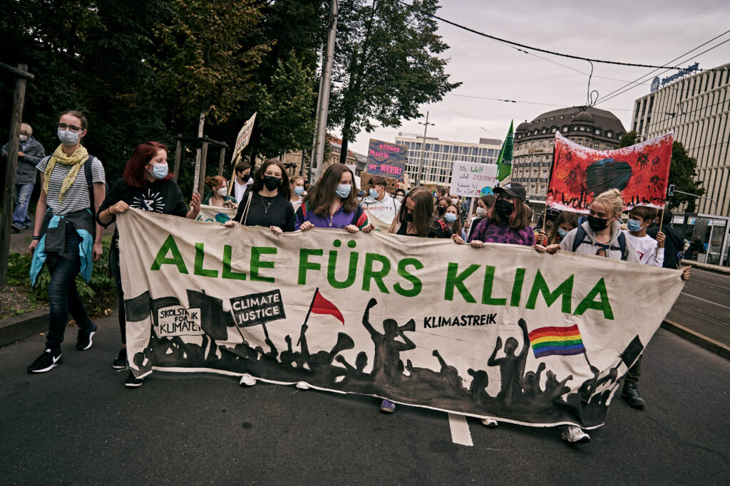 Mehrere Menschen laufen mit dem "Alle fürs Klima" Fronttransparent auf dem globalen Klimastreik.