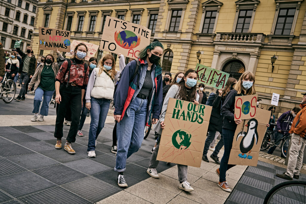 Mehrere Menschen halten Schilder auf dem Klimastreik von Fridays for Future Leipzig hoch.