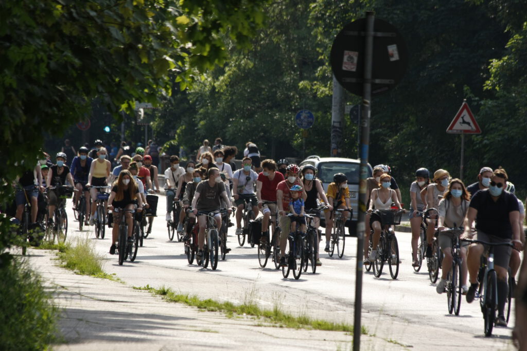Hunderte Menschen fahren auf einer Straße mit dem Fahrrad. Sie werden von Fahrrad-Polizist*innen eskortiert.